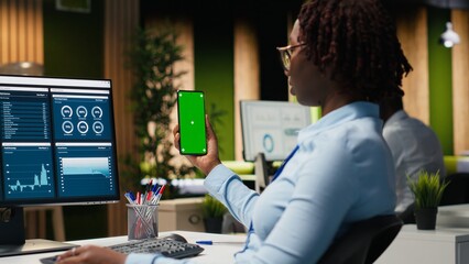 Isolated chroma key on mobile phone with business manager, working on report writing and reviewing data analytics late at night in office. Specialist building business strategy.