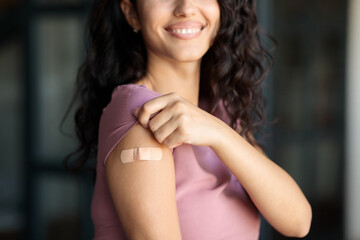Coronavirus prevention. Unrecognizable female patient showing arm with band aid after corona...