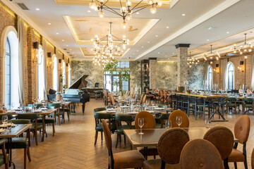 Modern hotel dining room with exposed brick walls and empty chairs