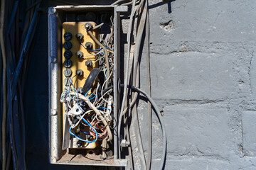 Open telecommunications junction box with exposed wiring on a wall, representing network distribution equipment, utility maintenance, and infrastructure operations
