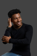 Smiling young woman posing confidently in a studio.