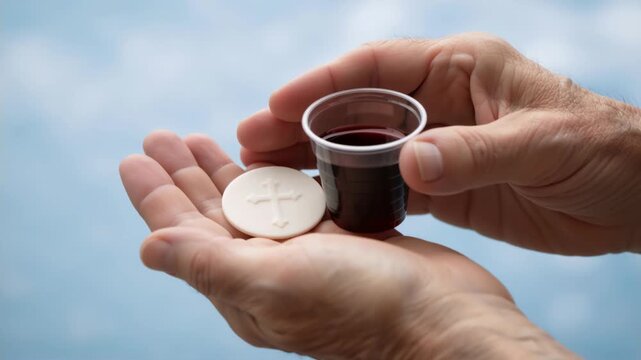 Hands holding communion wafer and wine cup. Close-up of elderly hands with Eucharist elements. Christian religious sacrament and faith concept