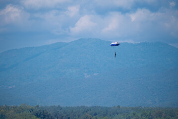 Skydivers are practicing with yellow, orange, and red parachutes for a skydiving competition at Mae Taeng Stadium, Chiang Mai, Thailand