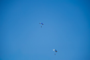 Skydivers are practicing with yellow, orange, and red parachutes for a skydiving competition at Mae Taeng Stadium, Chiang Mai, Thailand