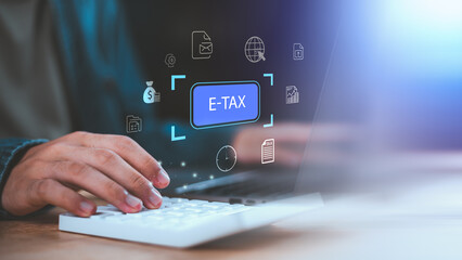 E-tax filing concept with business person using digital tax system on computer, representing online tax submission, electronic taxation, financial compliance, accounting process, government service