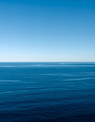 Obraz premium Tranquil seascape with deep blue waters and clear sky, ideal for travel, relaxation, and nature-themed projects.