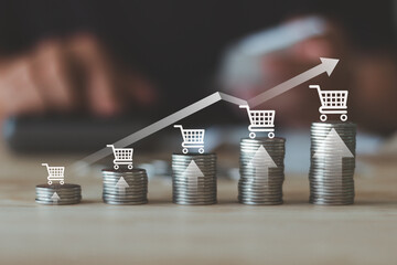 Ecommerce sales growth concept with shopping cart icons on stacked coins and upward arrow graph, online retail revenue increase, business performance, financial success and digital marketing strategy.