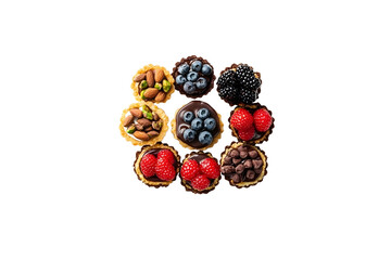 top view assorted tasty sweet tartlets with fresh berries chocolate nuts and pistachio on dessert white plate and isolated on white background