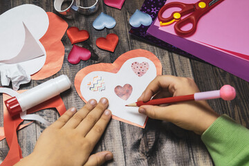 The child crafted a handmade valentine's greeting card, bearing messages of affection for his closest friends. © Marina