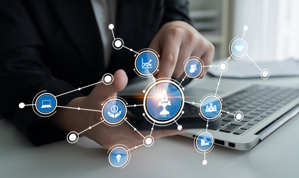 A business professional engages with a laptop, surrounded by digital icons symbolizing technology and data analysis, showcasing modern business solutions in an office environment. Crux - Powered by Adobe
