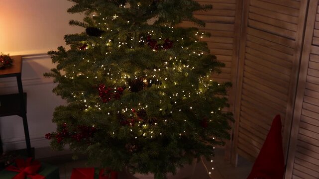 Beautiful Christmas tree and other festive decor indoors. Camera moving forward and down