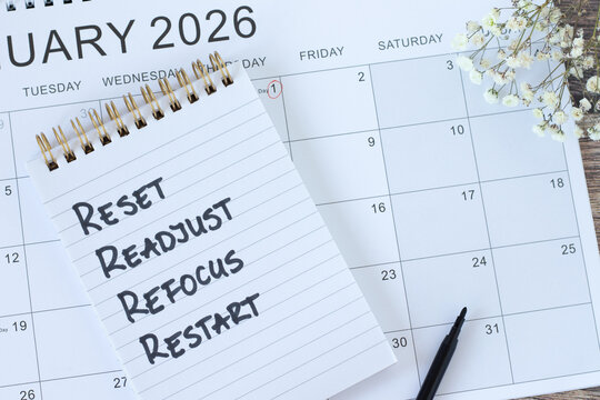 Reset, readjust, refocus, restart, inspirational checklist text in notebook with January 2026 calendar. Top view. New beginning, goals, success, and aspirations concept.