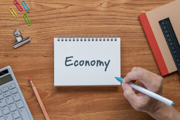 There is sticky note with the word Economy. It is as an eye-catching image.