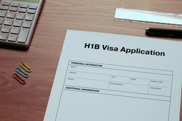 A dummy document of the H1B Visa Application is on the desk, along with a calculator and a pen.