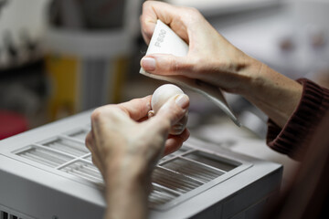 Artist sanding ball jointed doll head with sandpaper during customization and detailing process in doll workshop
