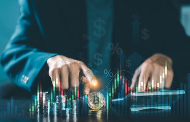 Businessman pointing at golden Bitcoin coin with virtual stock market financial graph. Concept of cryptocurrency investment and digital asset trading.