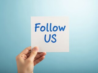 Hand holding a white card with follow us written in blue on a blue background