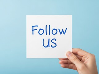 Hand holding white card with follow us written in blue on light blue background