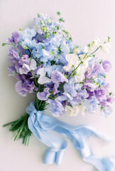 Delicate pastel sweet peas bouquet tied with a blue ribbon