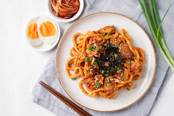 Stir fried Udon noodle with kimchi cabbage, pork, spring onion, sesame seed and seaweed on top