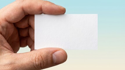 A person's hand offers a blank business card. A gesture of introduction or opportunity on a soft-focus background, highlighting communication and potential.
