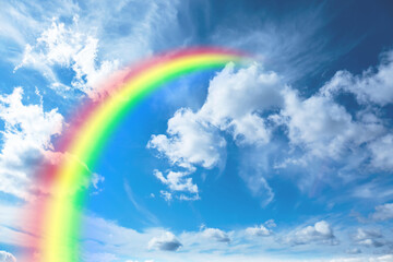 Bright colorful rainbow and clouds in blue sky