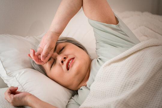 Senior woman unable to fall asleep in the bedroom (falling asleep, uncomfortable sleep, insomnia, quality of sleep)
