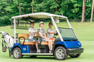 Female golfer riding a golf cart at a golf course (golf girl)