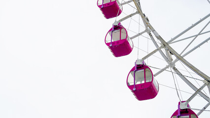 Amusement Park Ferris Wheel with Pink Gondolas. Pink gondolas on a ferris wheel in an amusement park setting. Outdoor recreational attraction symbolizing fun, tourism, and family entertainment © Imageswin