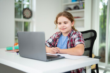 Kid preparing for exam with laptop. Student sitting at desk during distance education class. Smart child in virtual schoolwork and study. Child learning mathematics on laptop in home classroom.