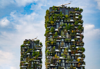 Green building with trees represents modern architecture in Milan. Bosco Verticale skyscraper. Sustainable architecture. Vertical forest tower in Italy. Modern apartments by greenery.