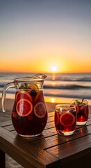 Refreshing fruit beverage pitcher and glasses sit on wooden surface against sunset ocean view