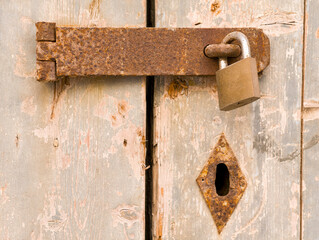 Rusty Padlock on Old Wooden Door
