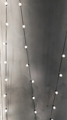 Minimalist aesthetic with string lights against a textured gray wall. subtle lighting and modern design create a serene atmosphere, perfect for home decor inspiration.