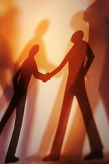 Business partnership handshake between two people in silhouette