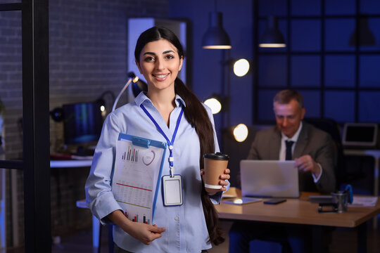 Female business analyst with diagrams in office at night. Data science concept