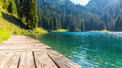 Wooden path beside clear lake surrounded by tall trees and mountains
