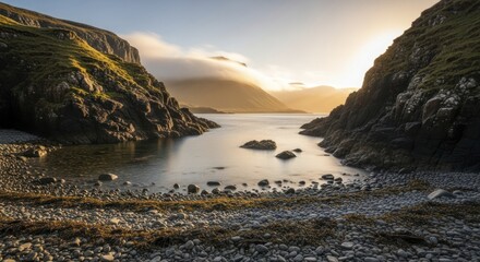Sunlight illuminates a tranquil sea inlet nestled between steep, grassy hillsides at dawn or dusk.