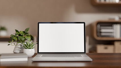 White screen laptop and books aside plant on wooden counter table across bookshelf in living room © bongkarn