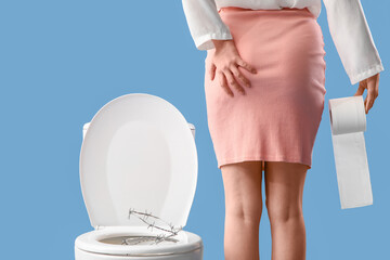 Young woman and toilet bowl with barbed wire on blue background, back view. Hemorrhoids concept