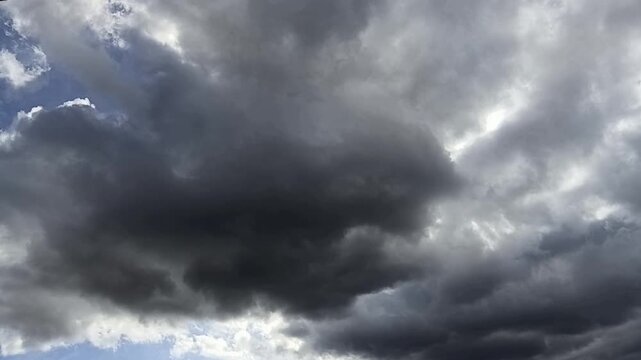 Un  cielo de azul con varias nubes  de color blanco y gris con un movimiento lento. Clima.
