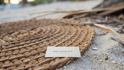 Textured Woven Mat on Sandy Ground with Inspirational Quote for Outdoor Relaxation and Calm Atmosphere