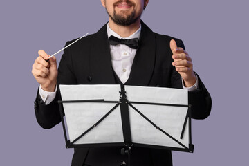 Male conductor with note sheets on grey background