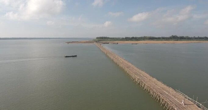 Aerial view of the Koh Paen bamboo bridge with a fishing boat passing underneath in Kampong Cham.