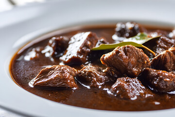 Close-up Shot of Gourmet Hachee Stew in a White Bowl on a Table Surface