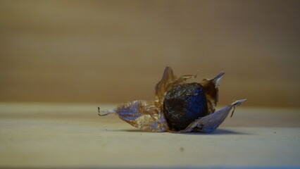 Pile of Single Clove Black Garlic, Allium sativum on Wood Background