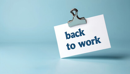 Paper sheet with the inscription back to work on soft blue background. Note with message and clip. Concept of return to workplace after vacation. Office supply as reminder. Memo with text.