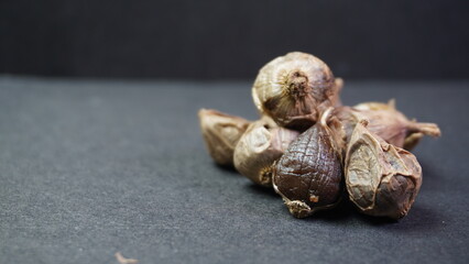 Fermented Single Clove Black Garlic, Allium sativum on Dark Background