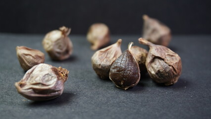 Fermented Single Clove Black Garlic, Allium sativum on Dark Background