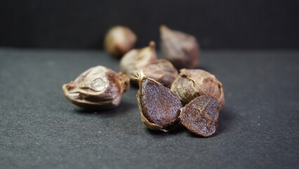 Fermented Single Clove Black Garlic, Allium sativum on Dark Background
